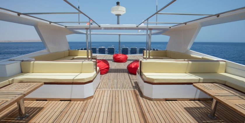 Luxury yacht deck with elegant seating and tables, offering a sophisticated and comfortable space for relaxation and socializing.