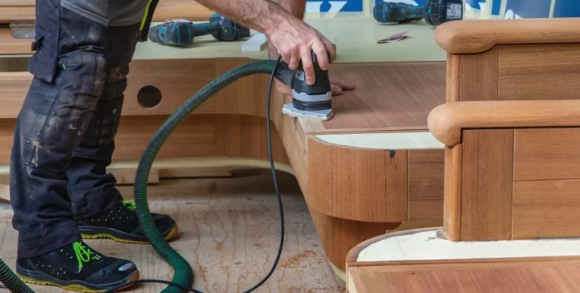 A carpenter working on yacht interior upholstery woodwork.