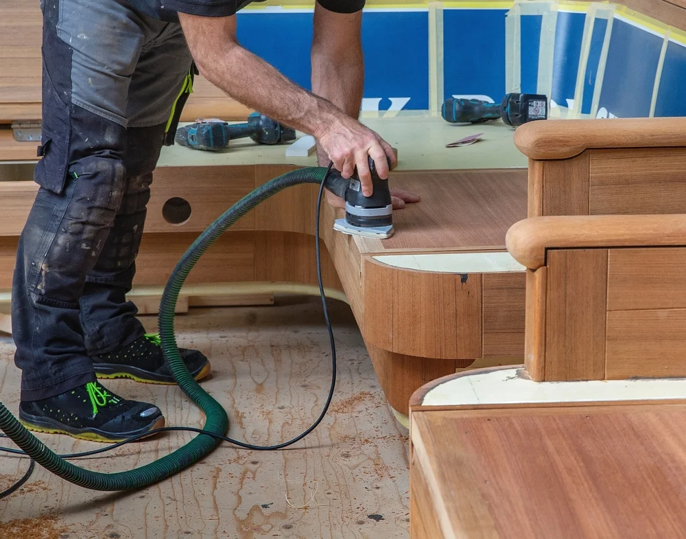 A carpenter working on yacht interior upholstery woodwork.