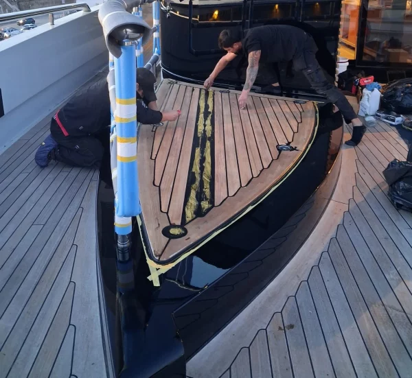 Teak deck on motor yacht being laid and recaulked.
