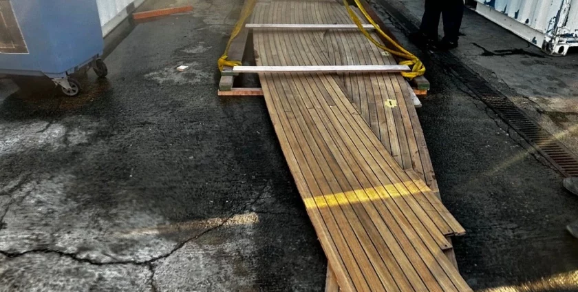 Teak deck wood laid outside on the ground.