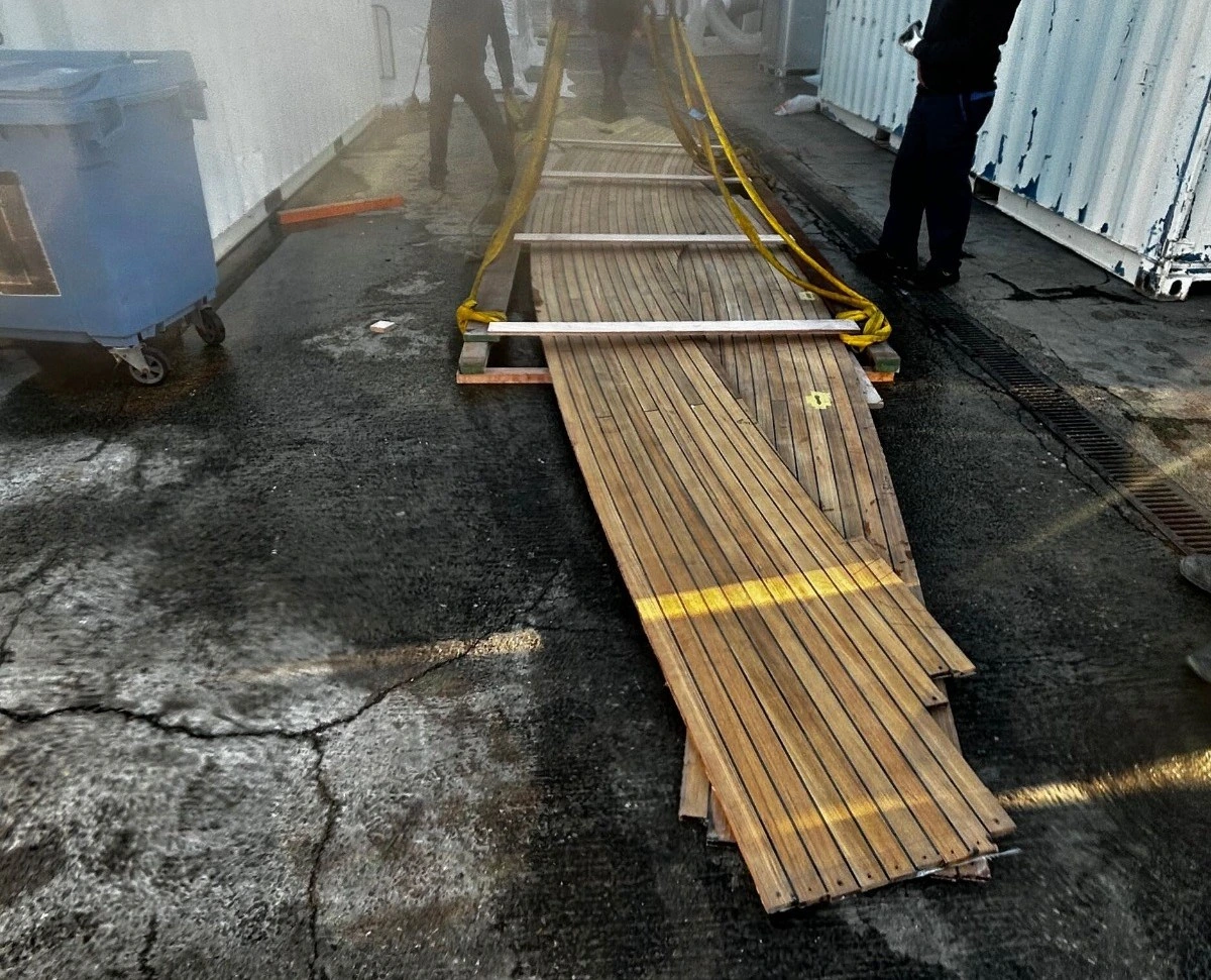 Teak deck wood laid outside on the ground.